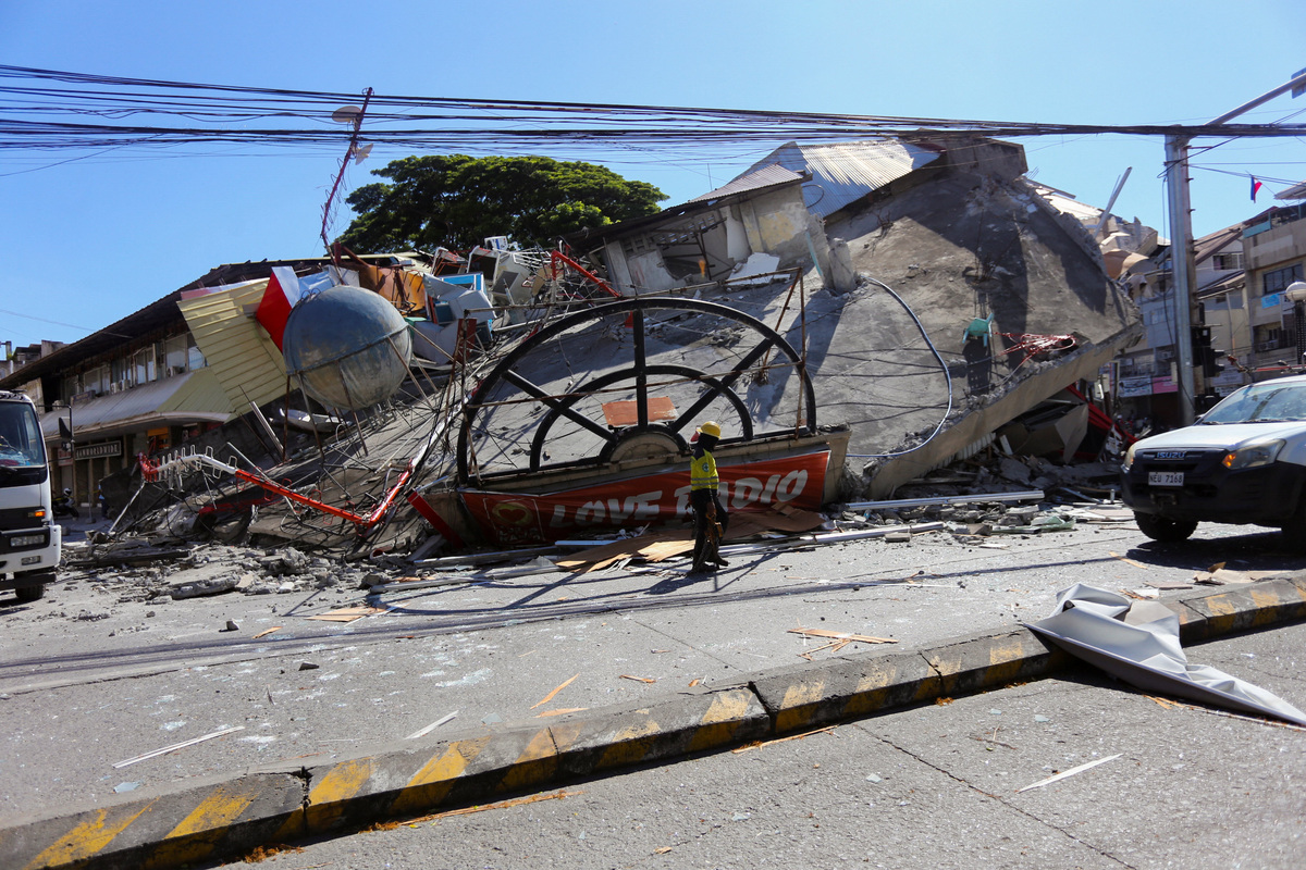 A worker walks near a collapsed building following the magnitude 7.8 quake in General Santos, southern Philippines, June 8, 2026. REUTERS/Manman Dejeto