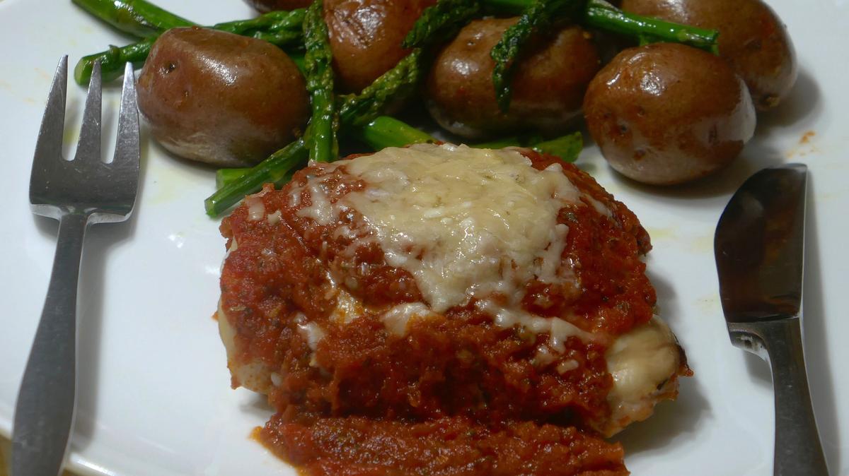 Savory oven-baked chicken thighs with roasted potatoes and asparagus. (Linda Gassenheimer/TNS)