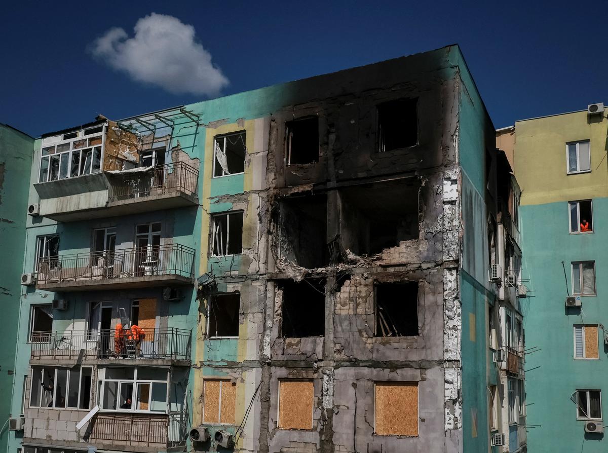 Communal workers install OSB boards in the places of broken windows at the site of an apartment building hit by a Russian drone strike, amid Russia's attack on Ukraine, amid Russia's attack on Ukraine, in Odesa, Ukraine May 1, 2026. REUTERS/Nina Liashonok