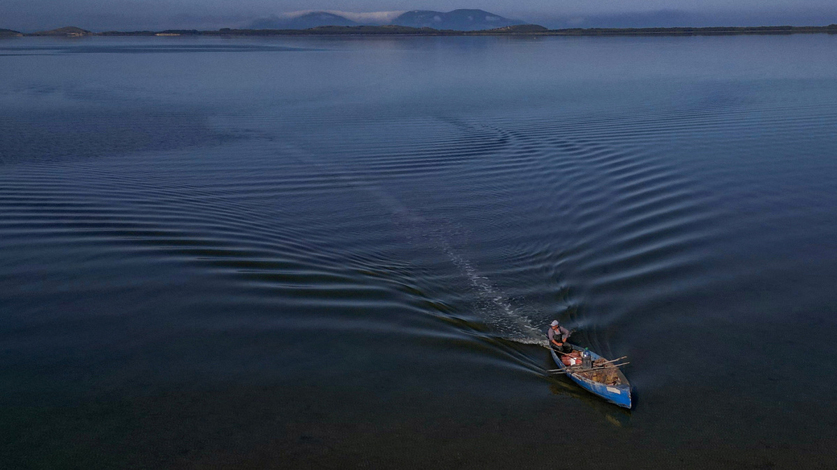 A drone view shows a fisherman sailing his boat near the Vjosa-Narta Protected Area, where a luxury resort is planned by a company linked to Donald Trump's son-in-law, Jared Kushner, on Wednesday in Zvernec near Vlora, Albania.