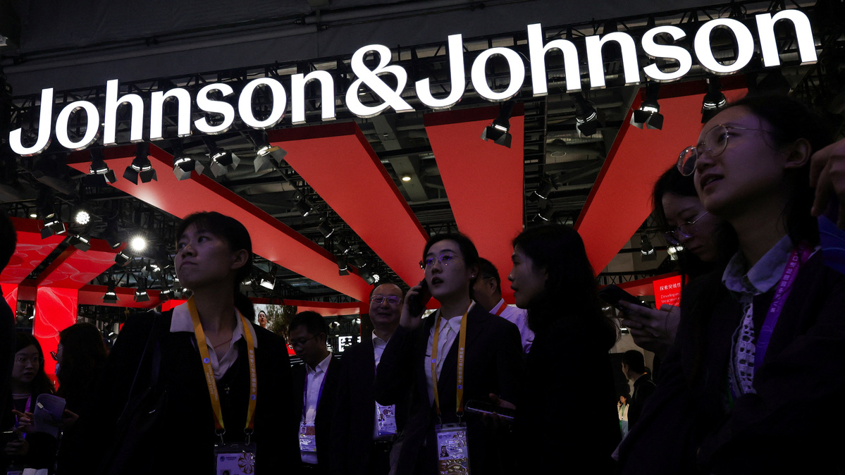 People gather next to a logo of Johnson & Johnson at the company’s booth at the 8th China International Import Expo (CIIE) in Shanghai, China, November 6, 2025.REUTERS/Maxim Shemetov