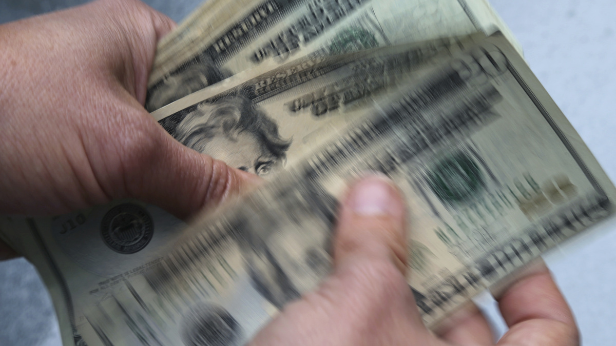 FILE- In this June 15, 2018, file photo, twenty dollar bills are counted in North Andover, Mass. More than half of older taxpayers (57%) are worried they’ll have to pay more taxes this year because of the 5.9% Social Security cost-of-living adjustment in 2022, according to a January survey by The Senior Citizens League.  (AP Photo/Elise Amendola, File).
