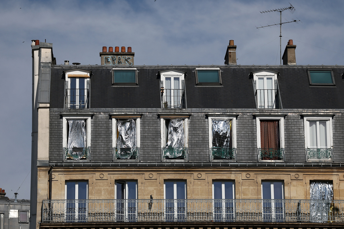 The windows of a Haussmann-style residential building are seen covered with emergency blankets to shield them from the sun as temperatures rise in Paris, during a heatwave affecting a majority of the country, France, June 25, 2026. REUTERS/Gonzalo Fuentes