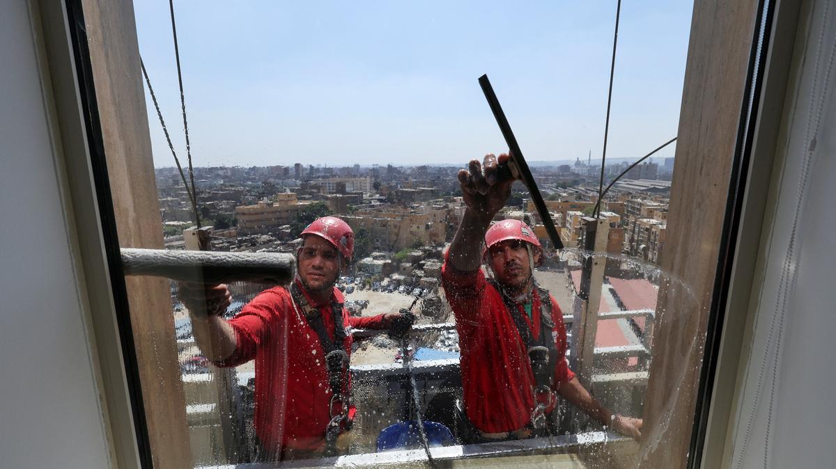 Egyptian workers clean the glass exterior of a building in Cairo, Egypt, May 6, 2026. REUTERS/Mohamed Abd El Ghany
