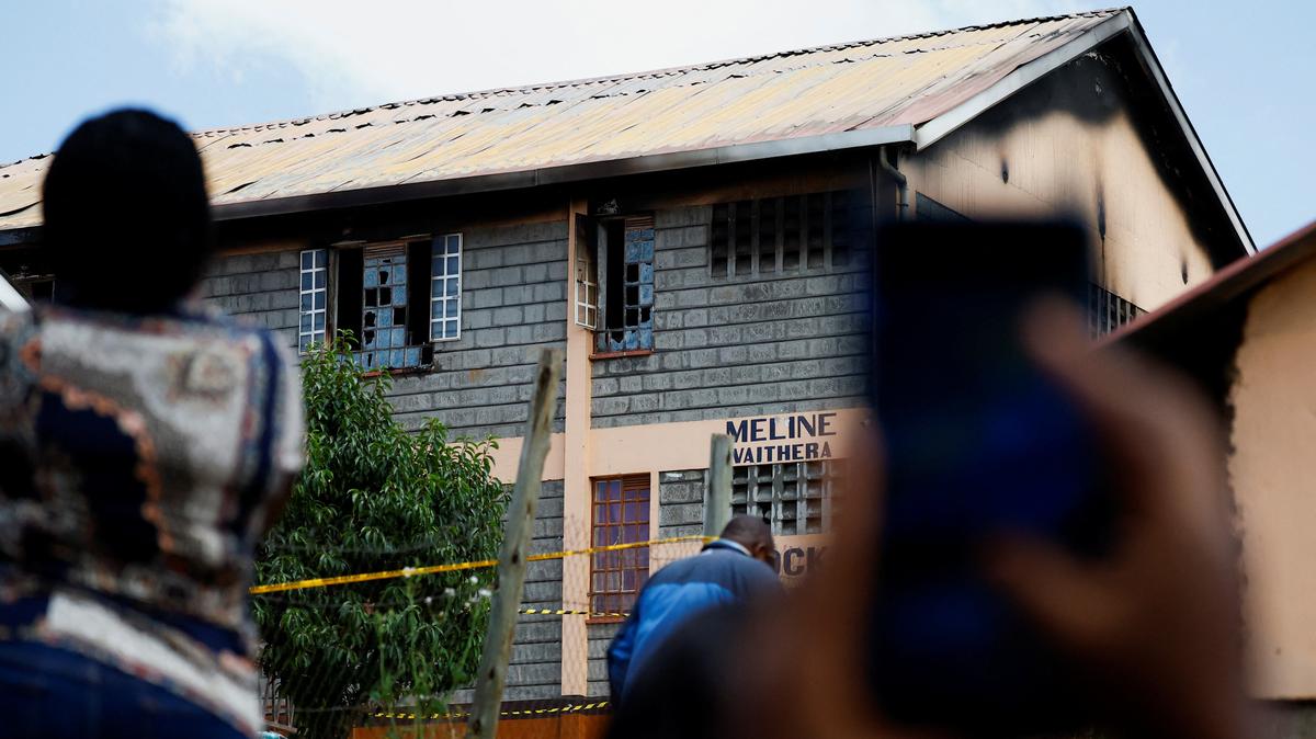 Parents take photographs of the ruins of a dormitory following an overnight fire at the Utumishi Girls' Academy Senior School in Gilgil, Nakuru county, Kenya, on Thursday.