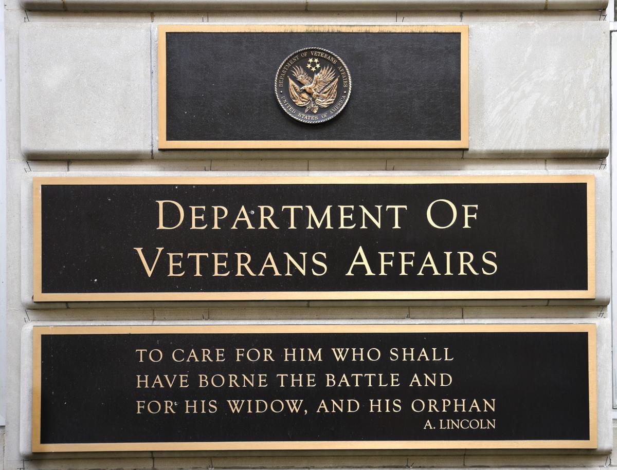 A metal plaque on the facade of the Department of Veterans Affairs building in Washington, D.C., features a quotation by Abraham Lincoln.