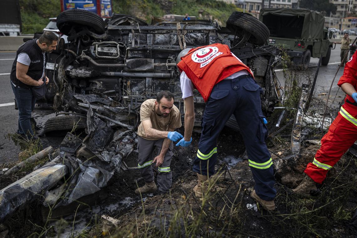 A Lebanese paramedic team, forensic investigators and Lebanese military collect evidence at the site of Israeli strikes on two vehicles along the Beirut-Saida highway, in Beirut, April 15, 2026. (Diego Ibarra Sánchez/The New York Times)