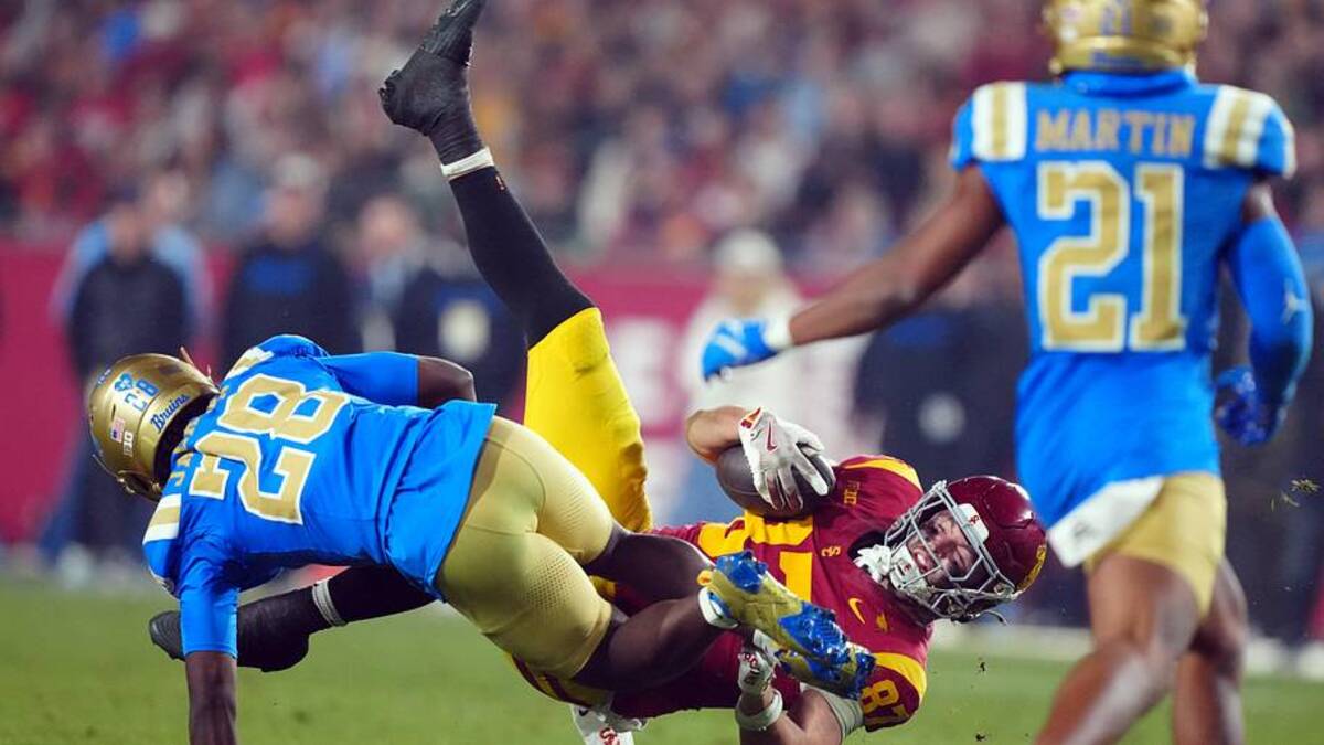  Nov 29, 2025; Los Angeles, California, USA; Southern California Trojans tight end Lake McRee (87) is tackled by UCLA Bruins defensive back Scooter Jackson (28) in the second half at United Airlines Field at Los Angeles Memorial Coliseum. Mandatory Credit: Kirby Lee-Imagn Images | Kirby Lee-Imagn Images 