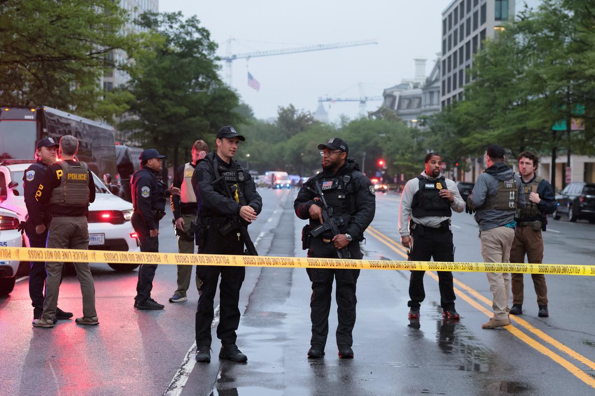 Law enforcement agents stand behind yellow tape near the White House, after gunshots were heard nearby, in Washington, D.C., U.S., May 23, 2026. REUTERS/Kylie Cooper