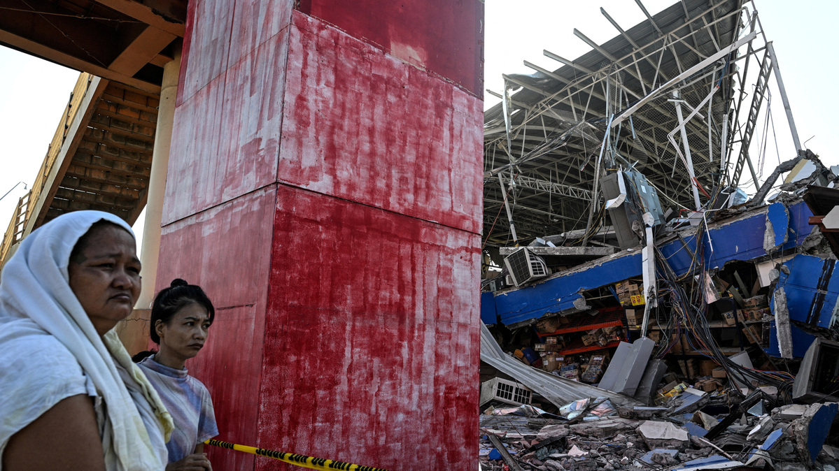 People look at a collapsed grocery store a day after the magnitude 7.8 earthquake, in Calumpang, General Santos, southern Philippines, June 9, 2026. REUTERS/Noel Celis