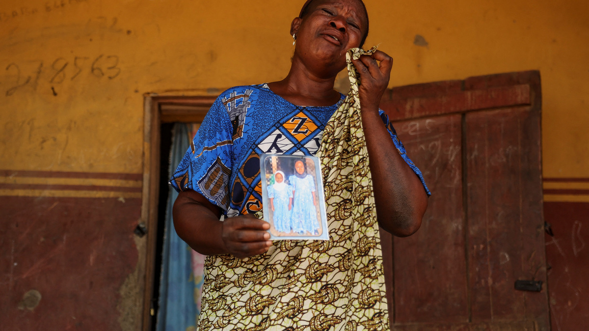 Aduke Balogun, whose daughter was among dozens of pupils and teachers abducted in a large-scale school attack in southwestern Nigeria, reacts while displaying her daughter's photograph and clothing after an interview with Reuters at her home in Yawota, Oyo State, Nigeria, June 2, 2026. REUTERS/Sodiq Adelakun