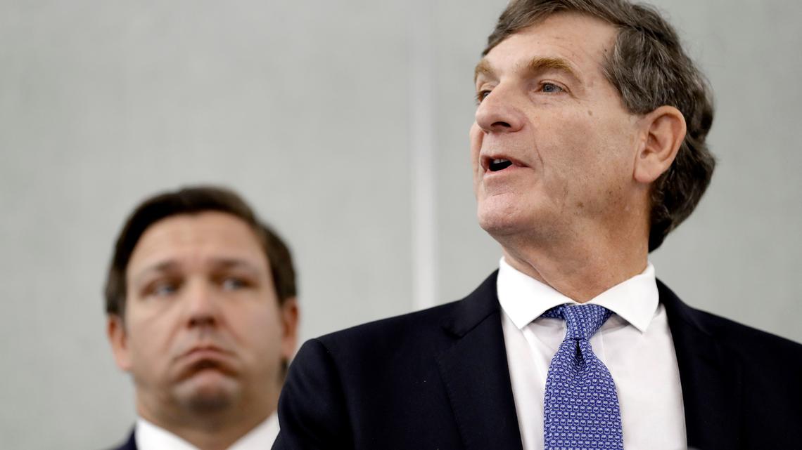 Florida Surgeon General Dr. Scott Rivkees, right, speaks to the media as Florida Gov. Ron DeSantis looks on during a news conference Monday, March 2, 2020, in Tampa.