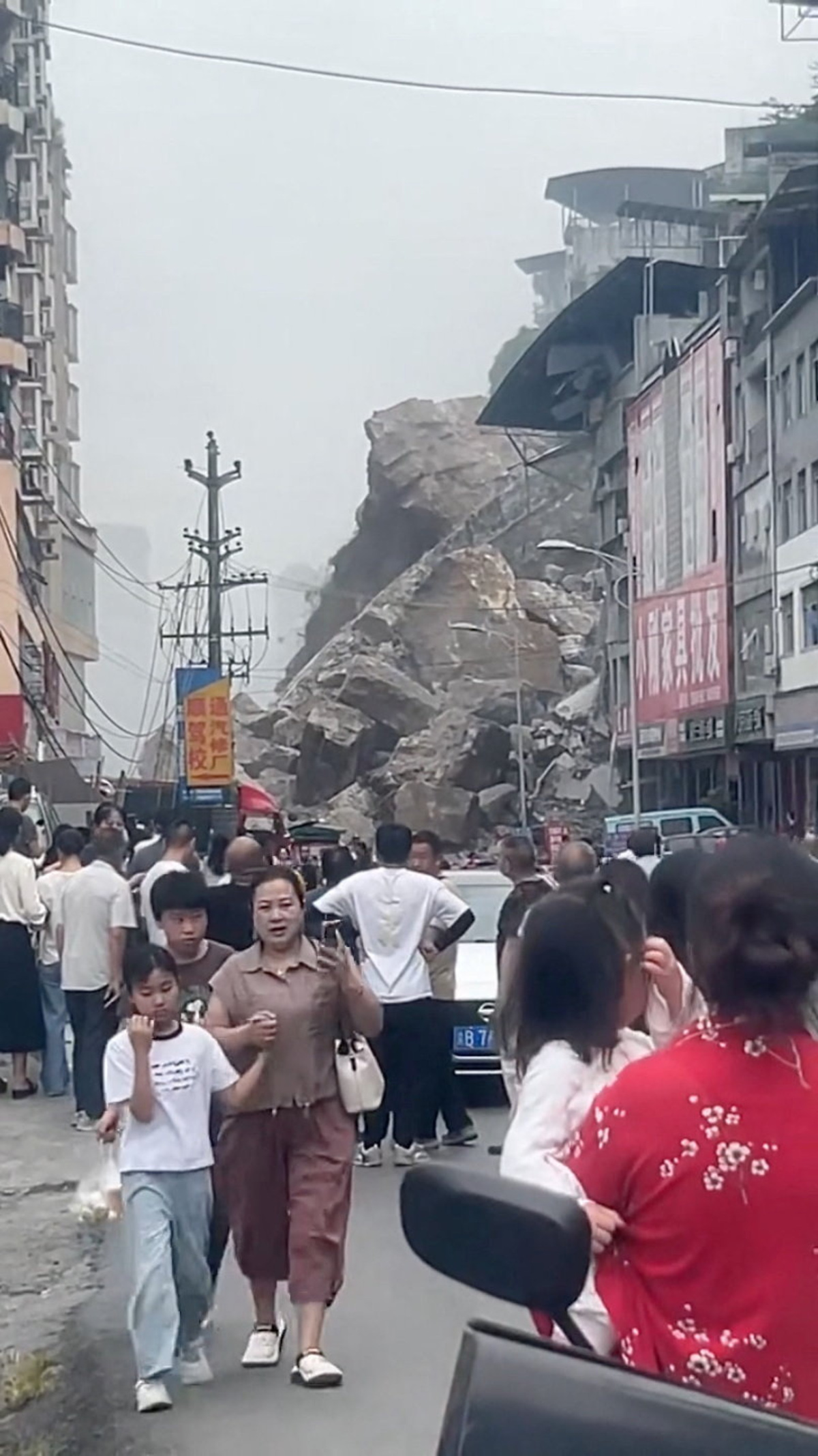 Debris and people at the site of buildings that collapsed due to a landslide in Chongqing, China, July 17, 2026, in this screengrab obtained from a social media video. Social Media/via REUTERS