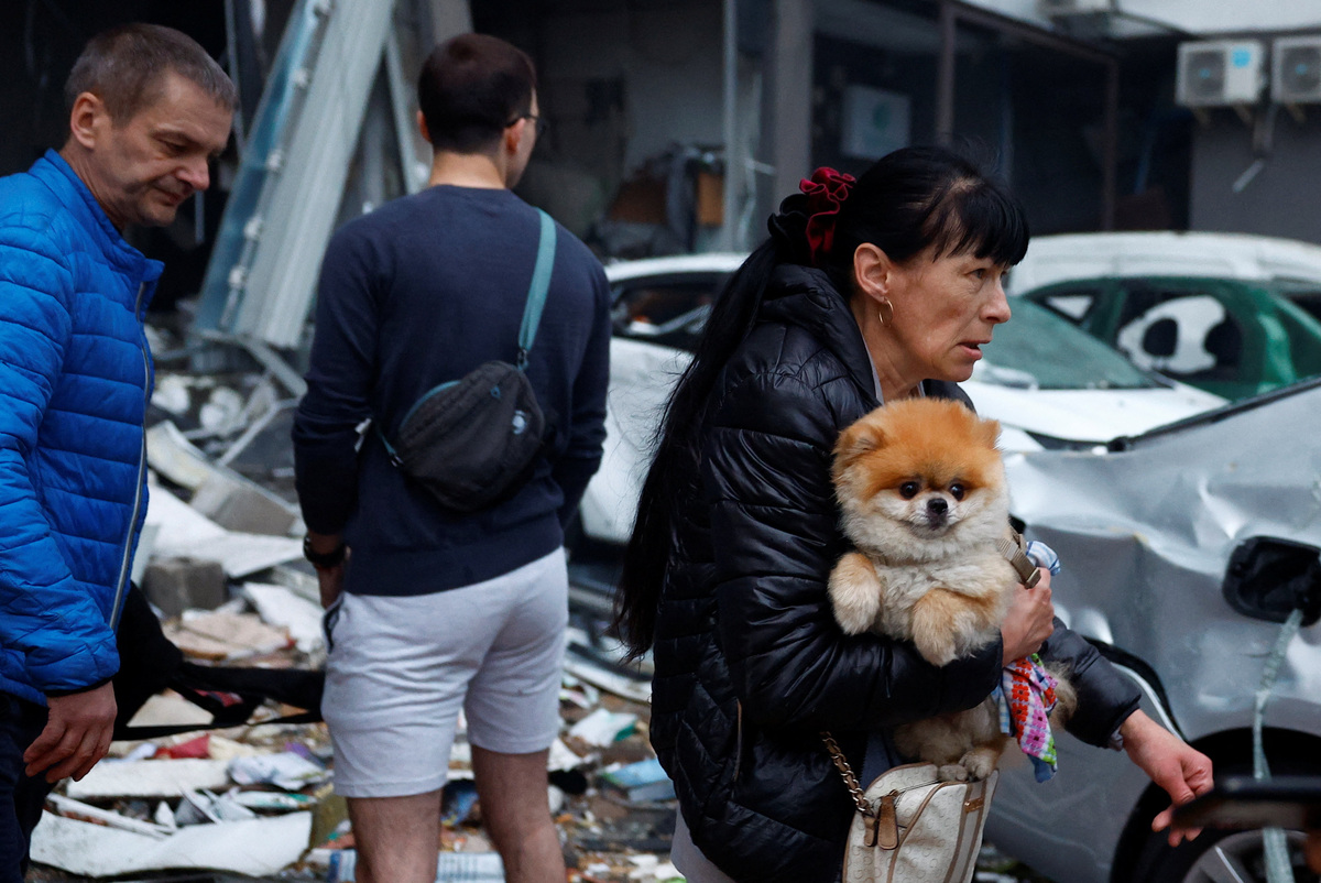 A woman carries a dog at the site of an apartment building, which was heavily damaged during Russian missile and drone strikes, amid Russia's attack on Ukraine, in Kyiv, Ukraine, July 6, 2026. REUTERS/Valentyn Ogirenko