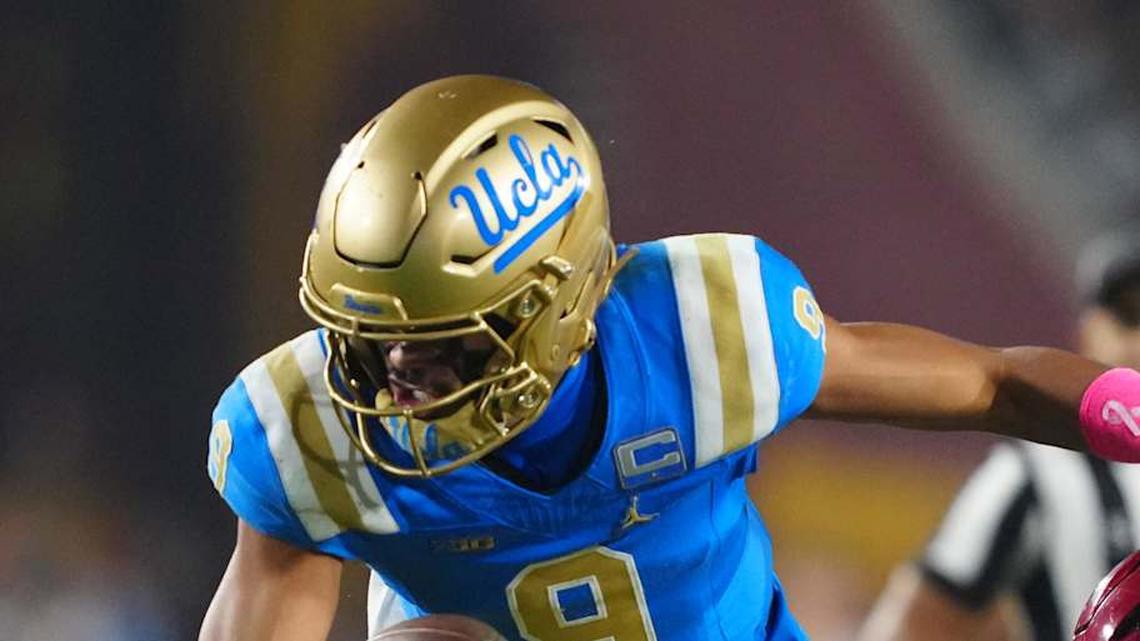  Nov 29, 2025; Los Angeles, California, USA; UCLA Bruins quarterback Nico Iamaleava (9) is tackled by Southern California Trojans linebacker Eric Gentry (18) in the second half at United Airlines Field at Los Angeles Memorial Coliseum. Mandatory Credit: Kirby Lee-Imagn Images | Kirby Lee-Imagn Images 