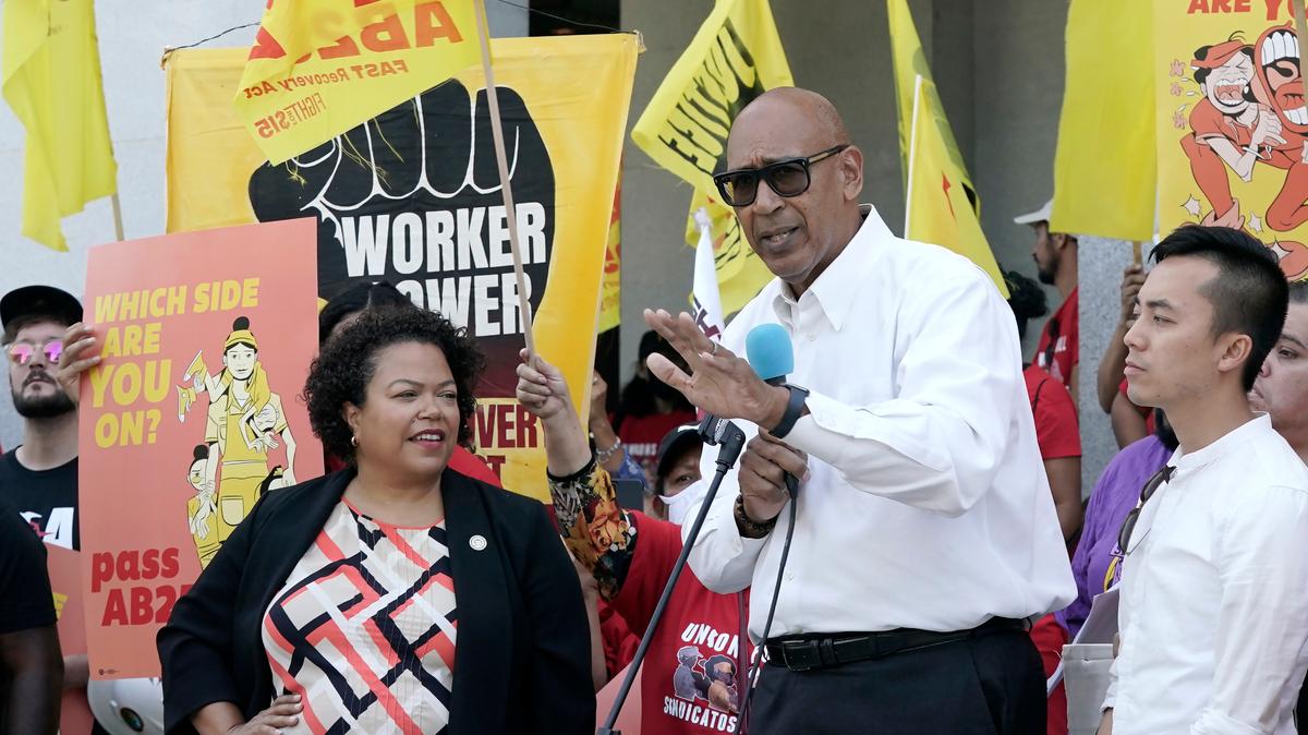 El asambleísta Chris Holden, demócrata de Los Ángeles, en el centro, habla de su proyecto de ley para dar más poder a los trabajadores de la comida rápida durante un mitin en Sacramento el 16 de agosto, antes de que fuera aprobado por los legisladores y promulgado por el gobernador Gavin Newsom.
