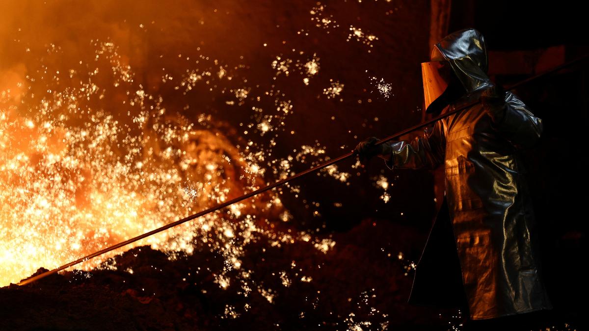 A steel worker stands amid sparks of raw iron coming from a blast furnace at a ThyssenKrupp steel factory in Duisburg, Germany, November 5, 2025. REUTERS/Leon Kuegeler