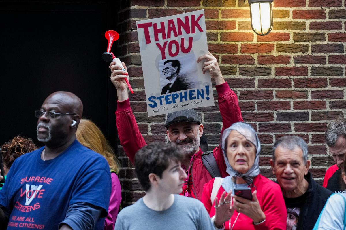 A person holds a sign outside of the Ed Sullivan Theater where the last show of Stephen Colbert’s Late Show is filmed, in New York City, U.S., May 21, 2026. REUTERS/Adam Gray