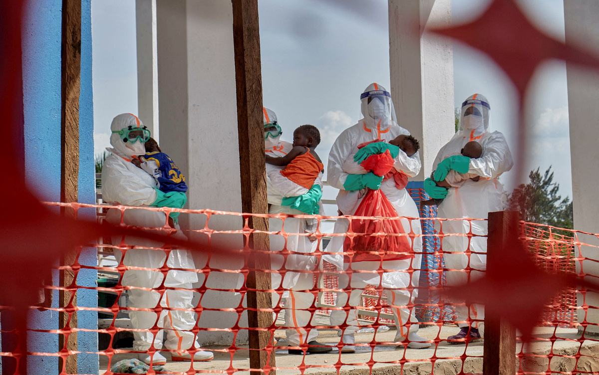 Congolese medical workers dressed in personal protective equipment (PPE) carry children tested and cleared off from Ebola from Saint Nicholas orphanage, at the Centre Medical Evangelique (CME) within the secured Ebola response zone, as aid agencies intensify efforts to contain the Ebola outbreak involving the Bundibugyo strain, in Hoho commune of Bunia town, Ituri province, Democratic Republic of Congo, June 9, 2026. REUTERS/Gradel Muyisa Mumbere