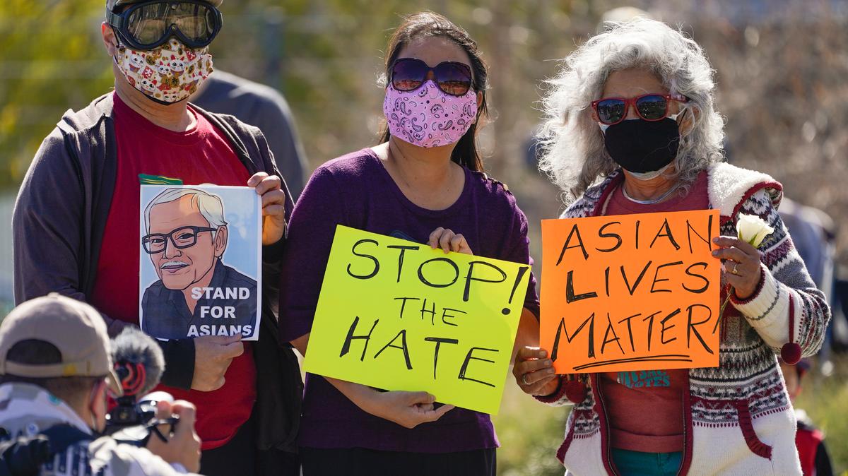 Un hombre sostiene un retrato de Vichar Ratanapakdee (izq.), el inmigrante tailandes de 84 años que murió después de que fue violentamente empujado contra el suelo en San Francisco, durante una manifestación contra el racismo hacia los asiáticos, cerca de Chinatown en Los Ángeles, el sábado 20 de febrero de 2021. Las otras dos pancartas dicen “detengan el odio” y “las vidas de los asiáticos importan”.