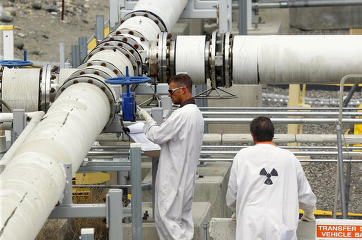 FILE - In this July 9, 2014, file photo, workers wearing protective clothing and footwear inspect a valve at the “C” tank farm on the Hanford Nuclear Reservation near Richland, Wash. 