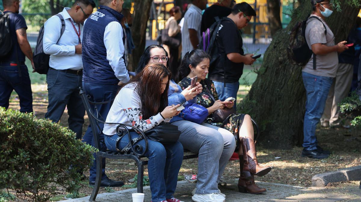 People sit on a bench while they wait outside, after an earthquake alarm sounded warning of a tremor, in Mexico City, Mexico, May 4, 2026. REUTERS/Luis Cortes