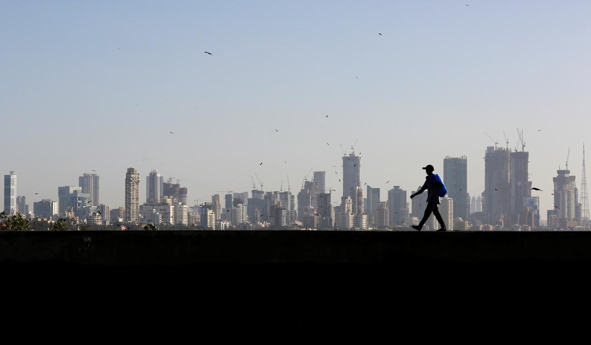 A man walks along a wall overlooking the central Mumbai's financial district skyline, India, March 9, 2017. REUTERS/Danish Siddiqui