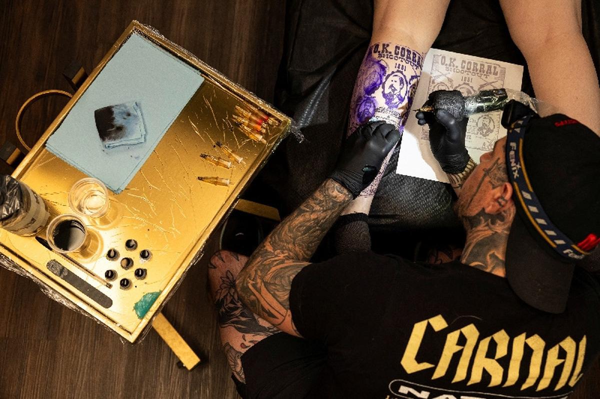 Randolph Torres tattoos the leg of Lexys Siebrands in Fort Morgan, Colorado, U.S., May 11, 2026.  REUTERS/Kevin Mohatt