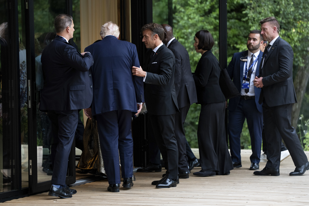 President Emmanuel Macron of France holds the arm of President Donald Trump as they attend a cultural performance at the G7 Summit in Evian-les-Bains, France, June 16, 2026. (Haiyun Jiang/The New York Times)