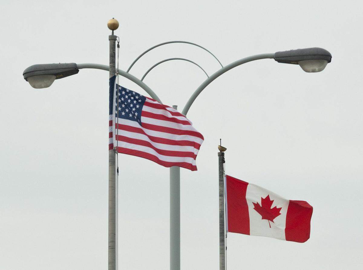American and Canadian flags wave side by side from the U.S. side of the Rainbow Bridge border crossing in Niagara Falls, New York.