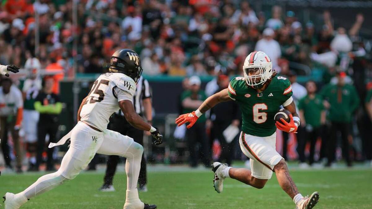  Nov 23, 2024; Miami Gardens, Florida, USA; Miami Hurricanes running back Damien Martinez (6) runs with the football against Wake Forest Demon Deacons defensive back Jamare Glasker (25) during the second quarter at Hard Rock Stadium. Mandatory Credit: Sam Navarro-Imagn Images | Sam Navarro-Imagn Images 