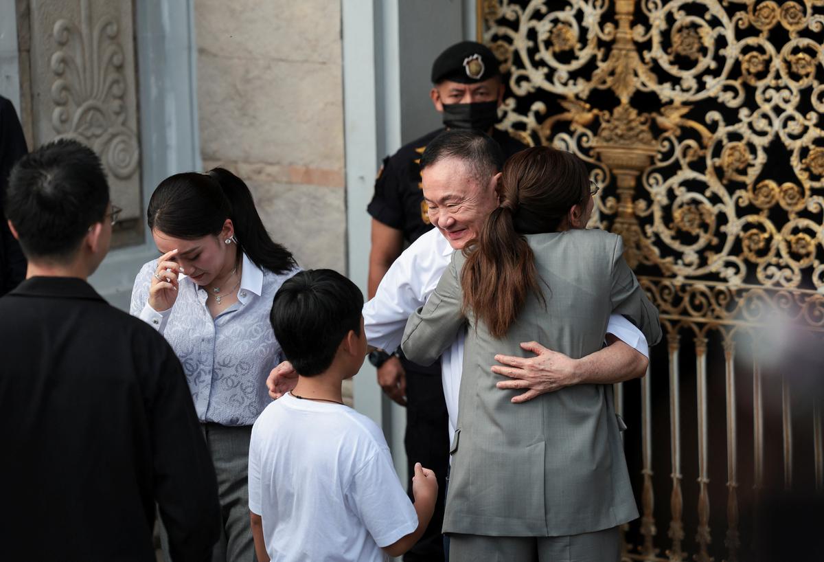 Former Thai Prime Minister Thaksin Shinawatra hugs his daughter, Pintongtha Kunakornwong, as former Thai Prime Minister Paetongtarn Shinawatra stands next to them, following his release on parole after serving eight months of his one-year sentence at Klong Prem Central Prison, in Bangkok, Thailand, May 11, 2026. REUTERS/Chalinee Thirasupa