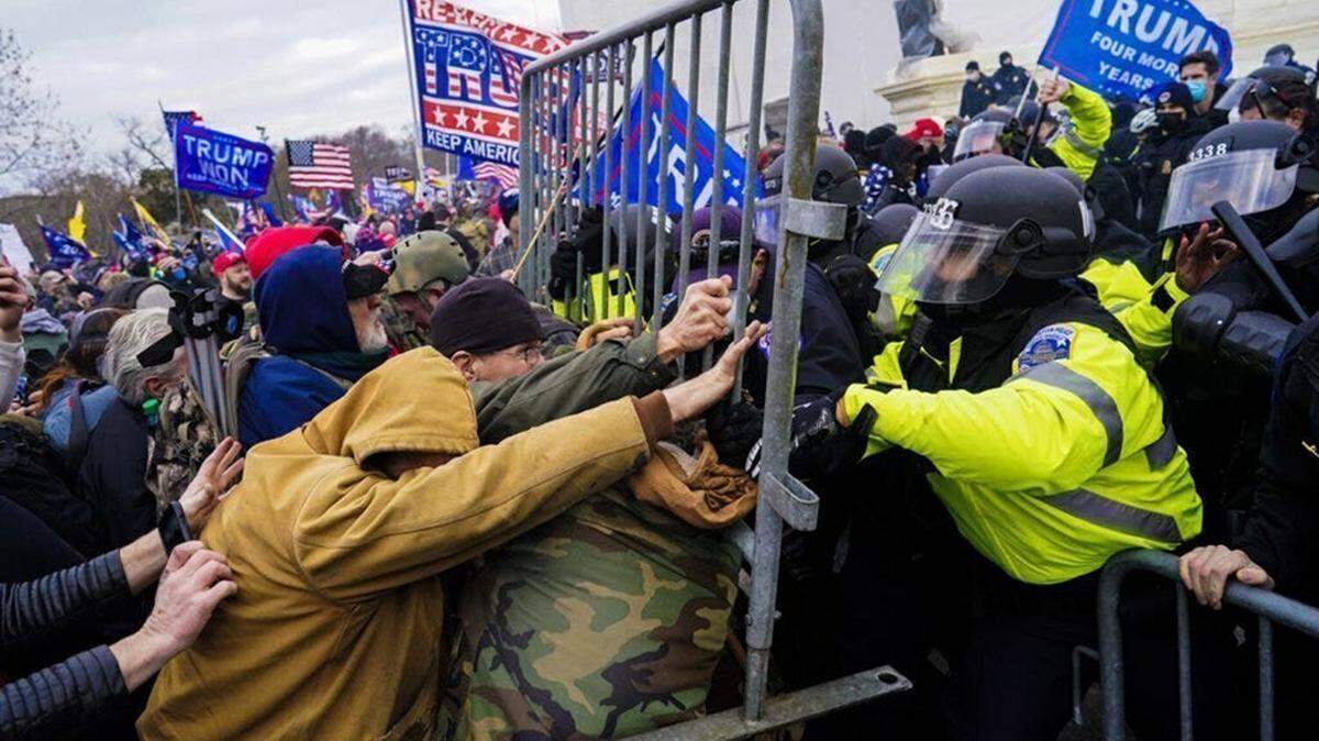 Rioters at the U.S. Capitol in Washington fight to break through a police barrier on Jan. 6, 2021. Some federal judges are pushing back on President Donald Trump’s pardon of the nearly 1,600 people charged in connection to the riot.