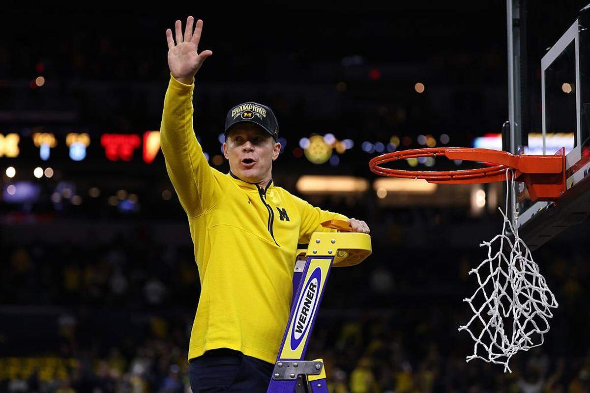 Michigan Wolverines men’s basketball coach Dusty May cuts down the net after his team defeated the UConn Huskies 69-63 for the 2026 national title at Lucas Oil Stadium in Indianapolis. 