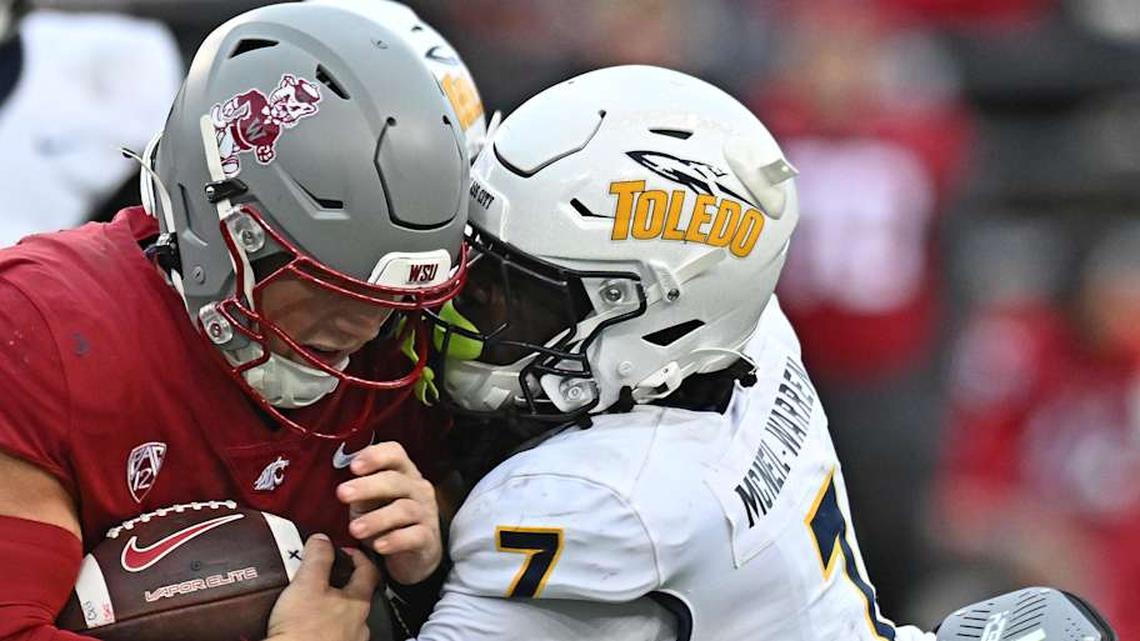  Oct 25, 2025; Pullman, Washington, USA; Washington State Cougars quarterback Zevi Eckhaus (4) is tackled by Toledo Rockets safety Emmanuel McNeil-Warren (7) in the second half at Gesa Field at Martin Stadium. Mandatory Credit: James Snook-Imagn Images | James Snook-Imagn Images 