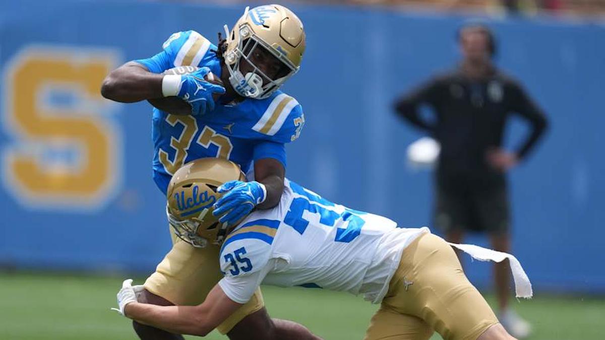  May 2, 2026; Pasadena, CA, USA; UCLA Bruins running back Karson Cox (33) is tackled by defensive back Logan Hirou (35)during the spring game at Rose Bowl. Mandatory Credit: Kirby Lee-Imagn Images | Kirby Lee-Imagn Images 