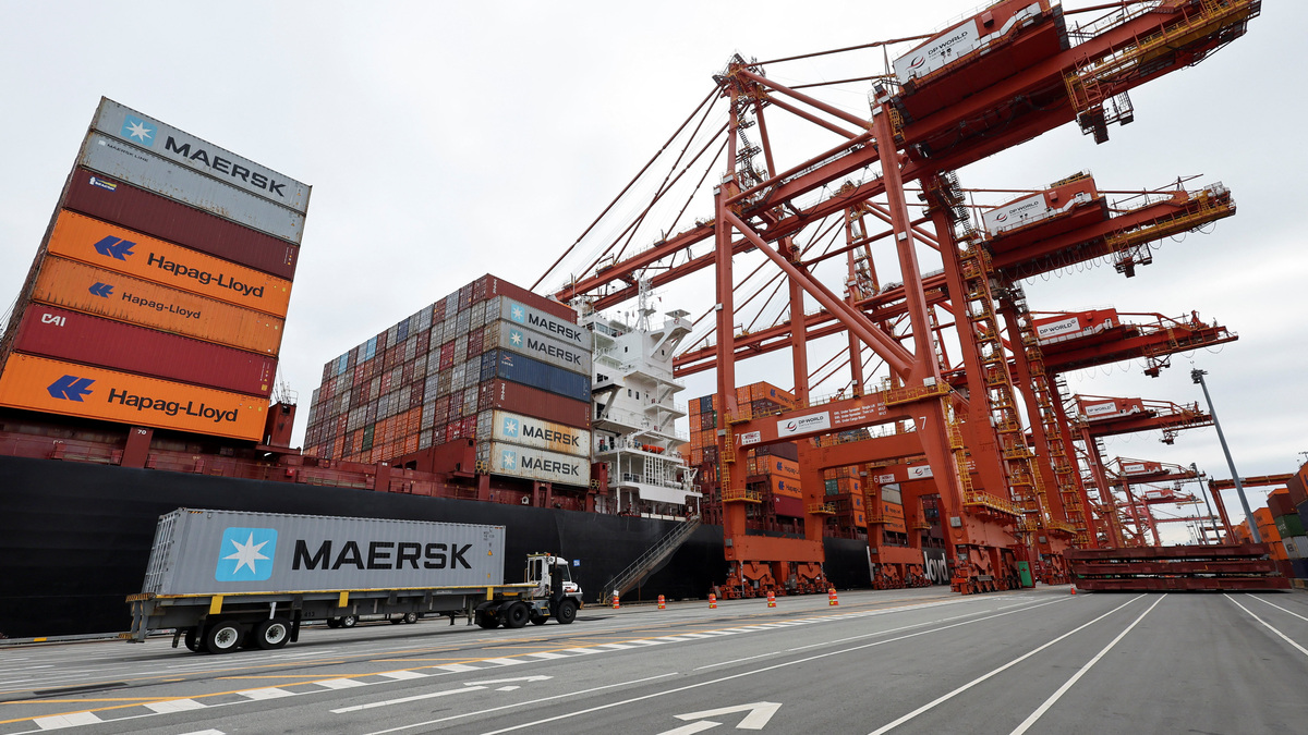A truck carries a container near a cargo ship at the Port of Vancouver in Vancouver, British Columbia, Canada August 3, 2025.  REUTERS/Chris Helgren