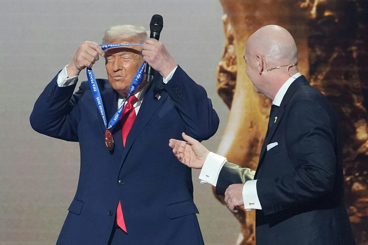  President Donald Trump puts on the inaugural FIFA Peace Prize presented to him by FIFA President Gianni Infantino. AP Photo/Evan Vucci 
