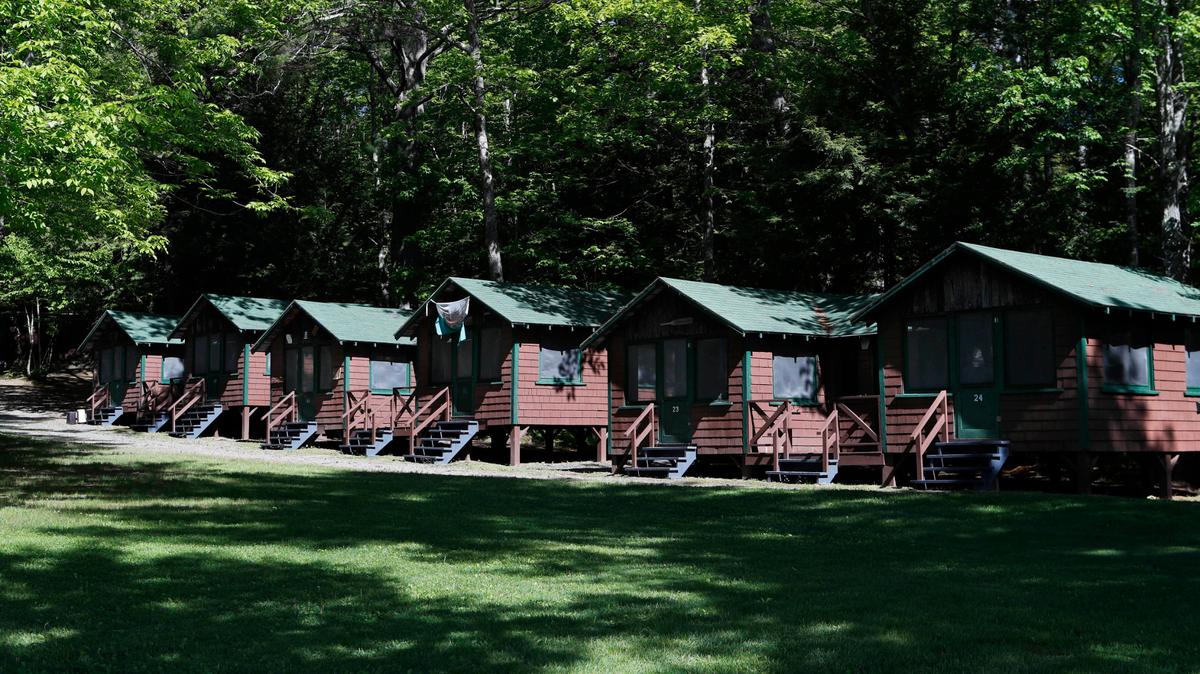 FILE - This Thursday, June 4, 2020 file photo shows a row of cabins at a summer camp in Fayette, Maine. On Friday, May 28, 2021, the Centers for Disease Control and Prevention posted guidance saying kids at summer camps can skip wearing masks outdoors, with some exceptions. Children who aren’t fully vaccinated should still wear masks outside when they’re in crowds or in sustained close contact with others – and when they are inside, and fully vaccinated kids need not wear masks indoors or outside, the CDC says. (AP Photo/Robert F. Bukaty, File)