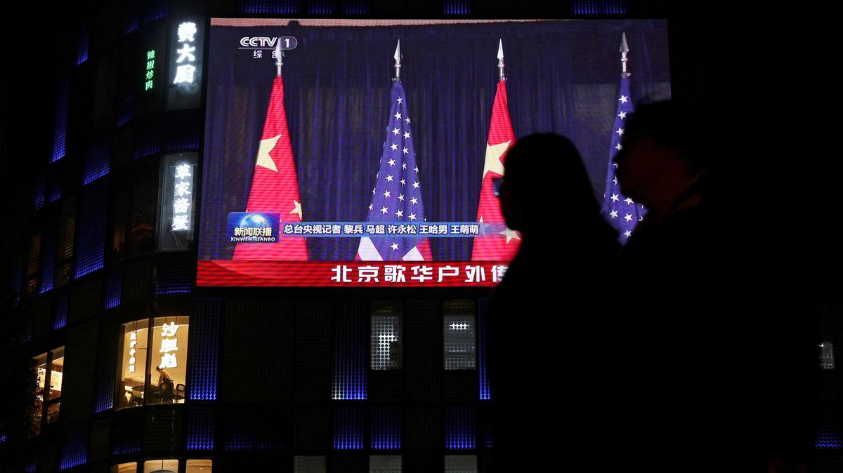 FILE PHOTO: A large screen shows news footage of Chinese and U.S. flags during the bilateral meeting between Chinese President Xi Jinping and U.S. President Donald Trump on the sidelines of the Asia-Pacific Economic Cooperation (APEC) summit in South Korea's Busan, outside a shopping mall in Beijing, China October 30, 2025. REUTERS/Florence Lo/File Photo