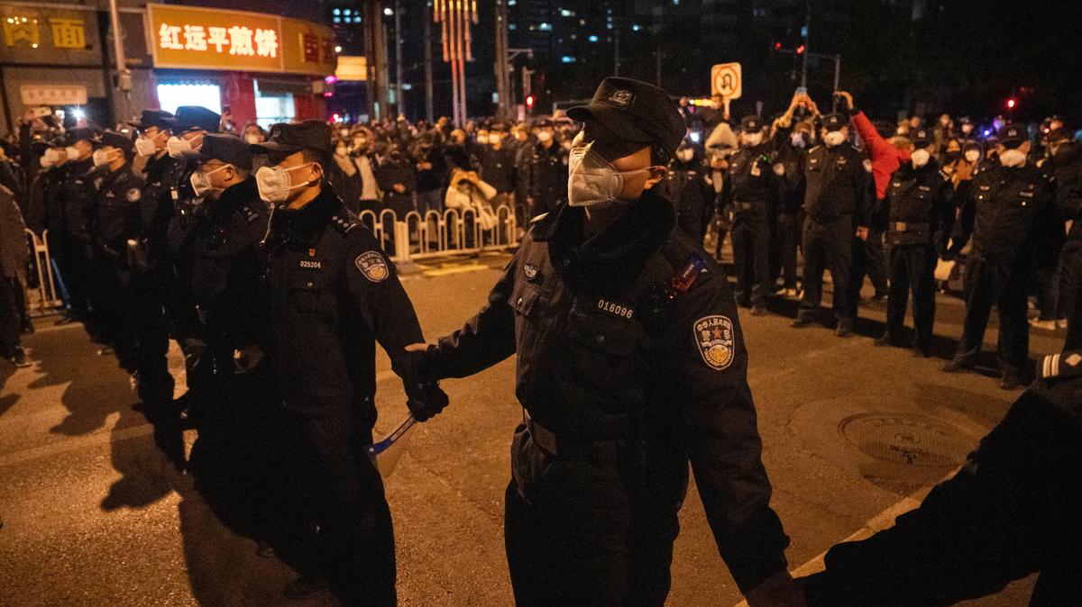 Chinese policemen form a line to stop protesters marching in Beijing on Nov. 27.
