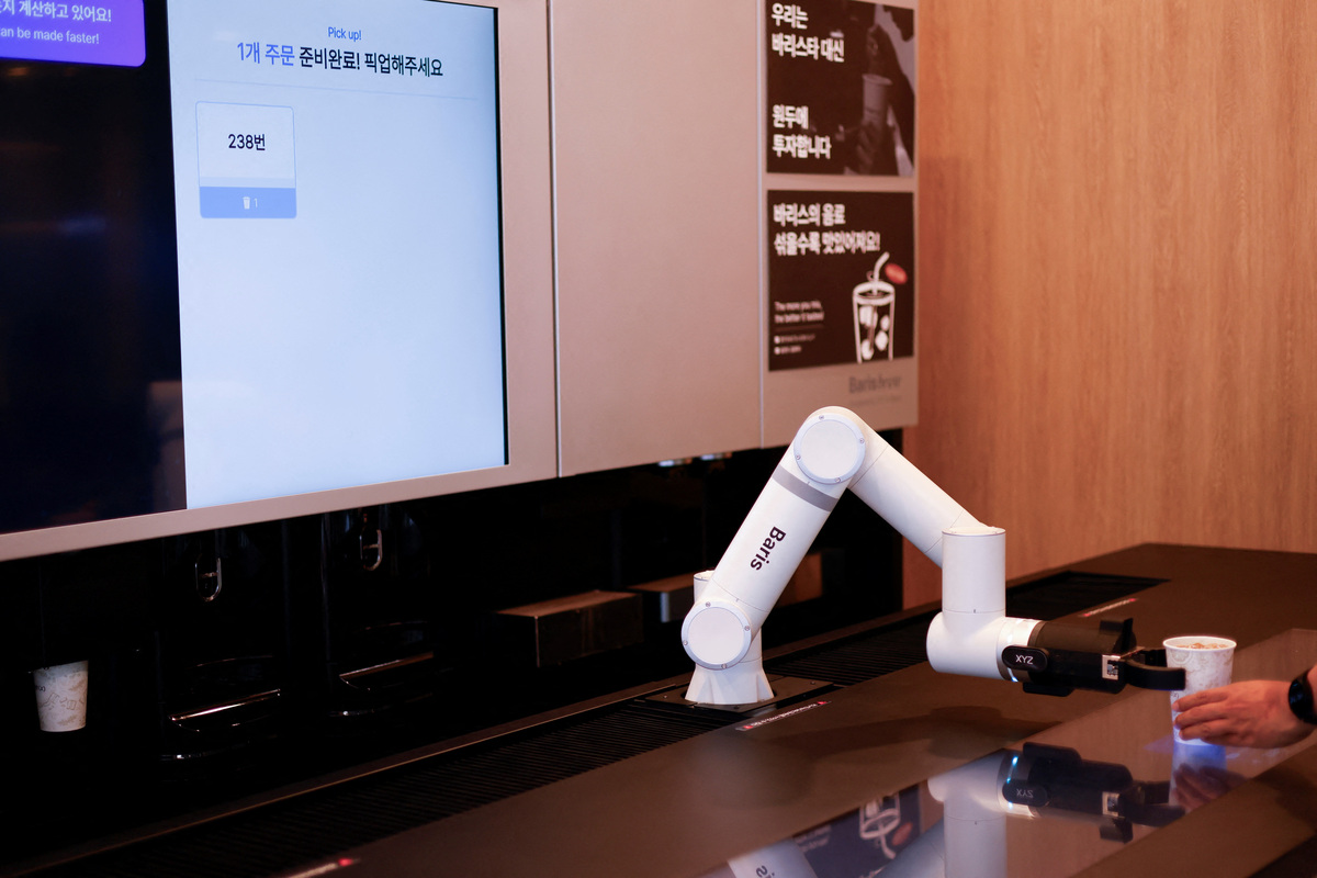 A robot arm serves coffee at an unmanned cafe in Seoul, South Korea, June 19, 2026. REUTERS/Kim Soo-hyeon