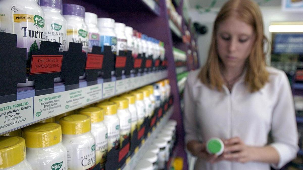 AUCKLAND, NEW ZEALAND - DECEMBER 11:  Avalon James looks over products in Ideal Health covered in black crosses that she will no longer be able to purchase if the government sign a treaty with Australia that will regulate the sale of health food products.  (Photo by Phil Walter/Getty Images)
