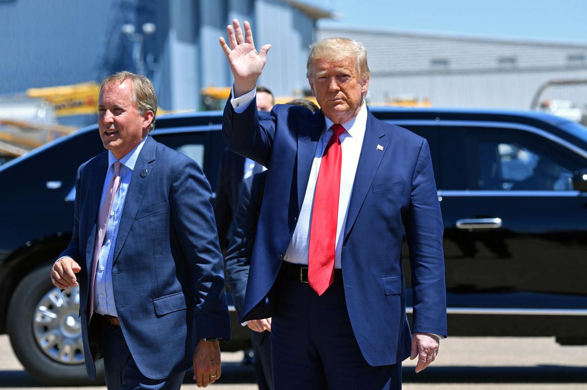  President Donald Trump (R) waves while walking alongside Texas Attorney General Ken Paxton in Dallas on June 11, 2020. 