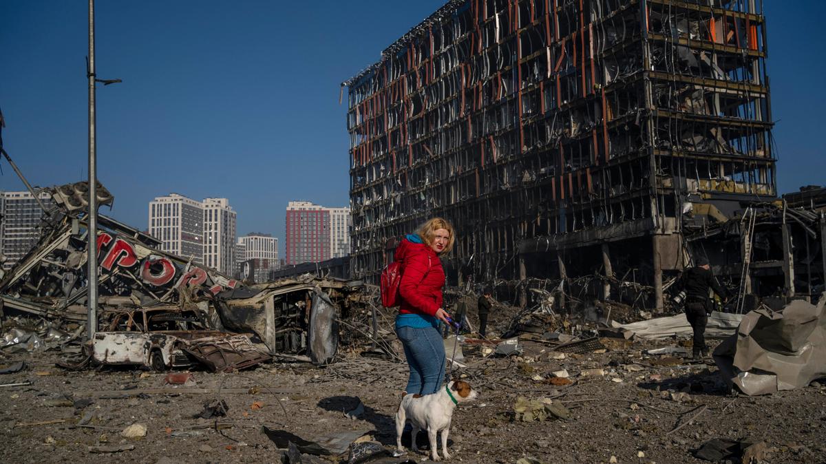Archivo - Irina Zubchenko pasea con su perro Max en medio de la destrucción causada tras un atentado con bomba en un centro comercial en Kiev, Ucrania, el 21 de marzo de 2022. (AP Foto/Rodrigo Abd, Archivo)