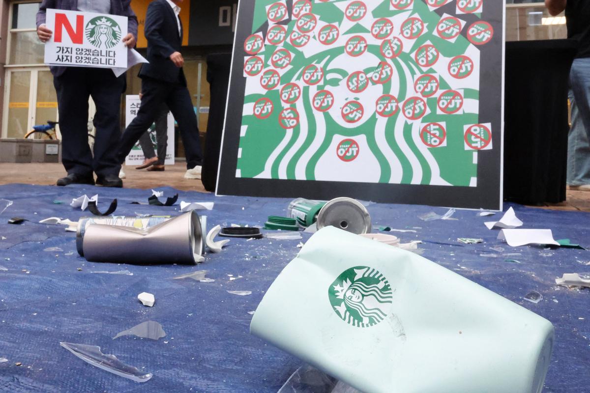 Shattered Starbucks tumblers and mugs lie scattered during a protest against Starbucks' "Tank Day" campaign, which was launched on the same day as the anniversary of the May 18 Gwangju uprising, when the then military government sent in troops and tanks to suppress mass rallies for democracy, in Gwangju, South Korea, May 21, 2026.   Yonhap via REUTERS