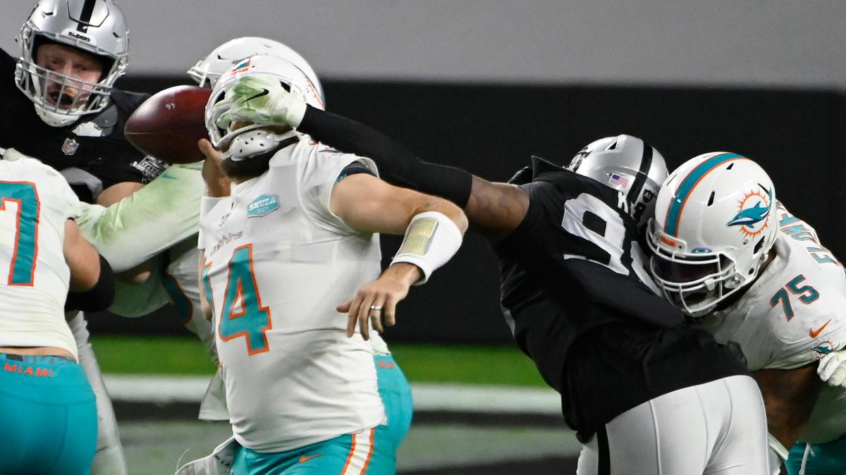 Las Vegas Raiders defensive end Arden Key (99) commits a roughing the passer penalty on Miami Dolphins quarterback Ryan Fitzpatrick (14) during the second half of an NFL football game, Saturday, Dec. 26, 2020, in Las Vegas. (AP Photo/David Becker)