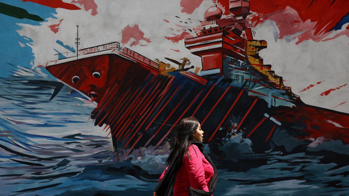 An Iranian woman walks next to a mural on a street in Tehran, Iran, May 6, 2026. Majid Asgaripour/WANA (West Asia News Agency) via REUTERS