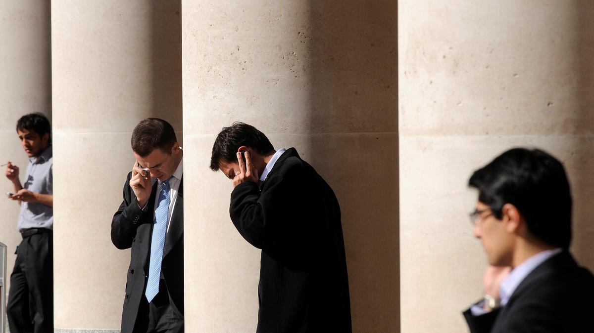 City workers make phone calls outside the London Stock Exchange in Paternoster Square in the City of London, Britain, October 1, 2008.  REUTERS/Toby Melville/File Photo