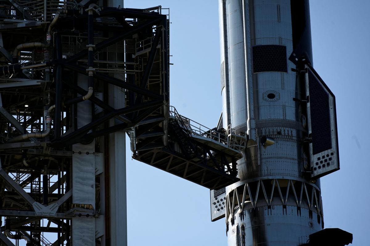 A giant mechanical arm holds the bottom of the SpaceX Starship spacecraft where it sits atop the Super Heavy Booster at the SpaceX launch complex in Starbase, Texas, U.S., May 22, 2026. A hydraulic pin on the launch tower’s arm did not retract as designed, stopping yesterday’s launch attempt seconds before its planned liftoff. REUTERS/Steve Nesius